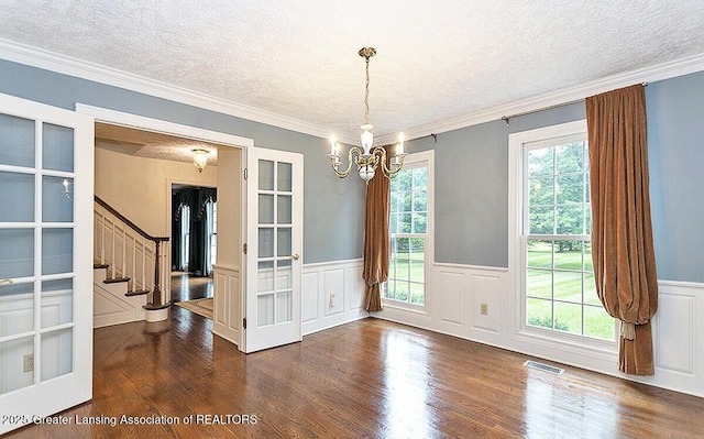 8505 W Willow Hwy, Grand Ledge, MI 48837 - unfurnished dining area featuring a textured ceiling, a chandelier, dark wood-style floors, stairway, and a wainscoted wall