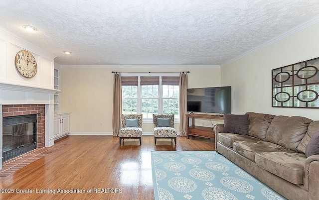 8505 W Willow Hwy, Grand Ledge, MI 48837 - living area with wood finished floors, a textured ceiling, crown molding, a brick fireplace, and baseboards