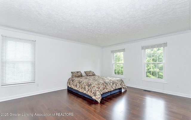 8505 W Willow Hwy, Grand Ledge, MI 48837 - bedroom featuring ornamental molding, wood finished floors, a textured ceiling, and baseboards