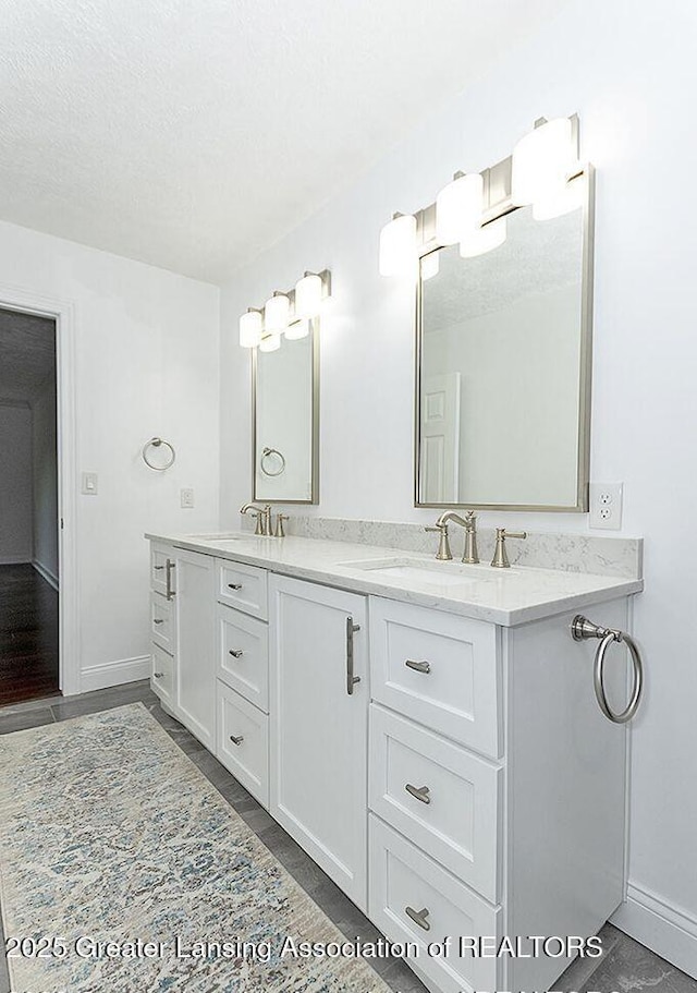 8505 W Willow Hwy, Grand Ledge, MI 48837 - bathroom featuring double vanity, baseboards, and a textured ceiling