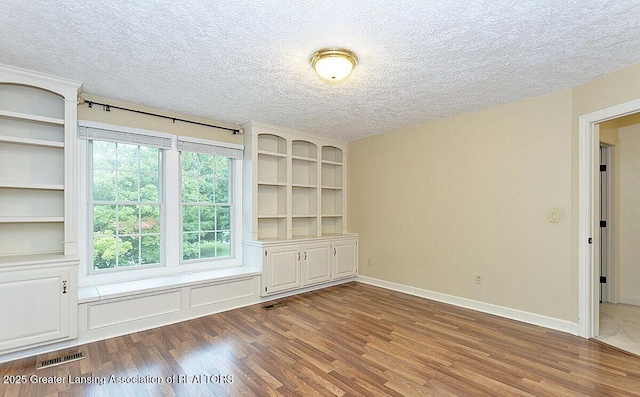 8505 W Willow Hwy, Grand Ledge, MI 48837 - spare room with wood finished floors, a textured ceiling, and baseboards