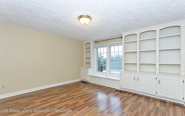 8505 W Willow Hwy, Grand Ledge, MI 48837 - unfurnished room featuring a textured ceiling, dark wood-style floors, and baseboards