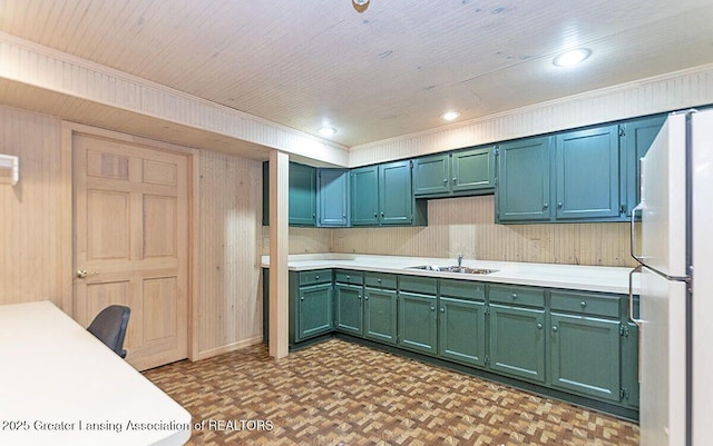8505 W Willow Hwy, Grand Ledge, MI 48837 - kitchen with freestanding refrigerator, a sink, green cabinets, light countertops, and wooden walls