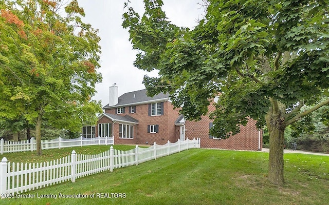 8505 W Willow Hwy, Grand Ledge, MI 48837 - back of property with a chimney, a sunroom, and brick siding