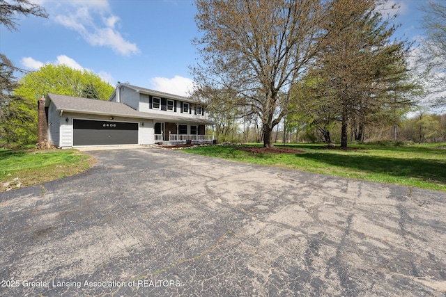 view of front of house featuring an attached garage, a front yard, a porch, and aphalt driveway