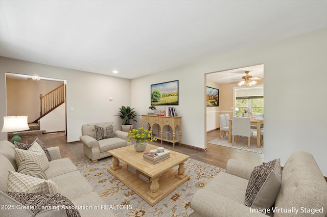 living room featuring stairs, a ceiling fan, baseboards, recessed lighting, and wood finished floors