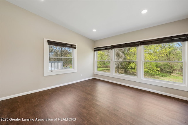 spare room featuring baseboards, vaulted ceiling, recessed lighting, and dark wood-type flooring