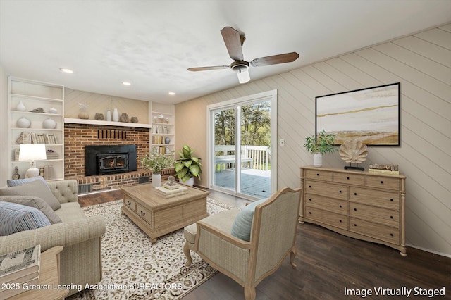living area with a ceiling fan, built in features, wood finished floors, wooden walls, and recessed lighting