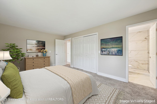 carpeted bedroom featuring baseboards, ensuite bathroom, and a closet