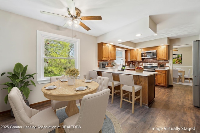 dining area featuring baseboards, recessed lighting, dark wood finished floors, and ceiling fan