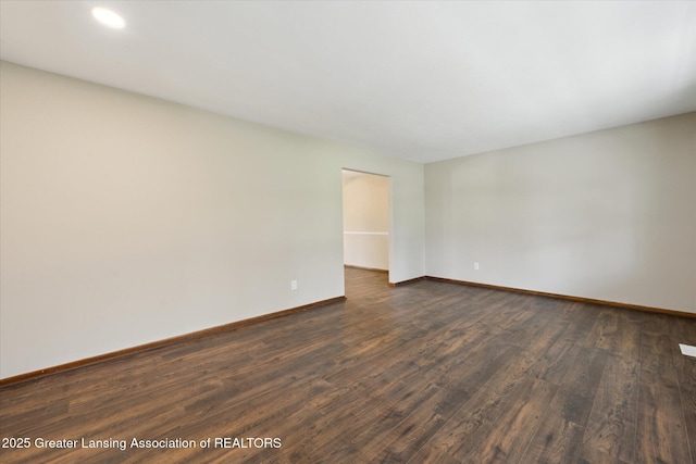 empty room with recessed lighting, baseboards, and dark wood-style flooring
