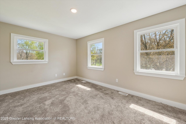carpeted empty room with baseboards and visible vents