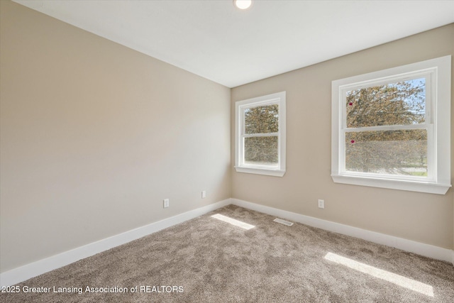 unfurnished room with carpet floors, baseboards, and visible vents