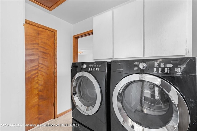 washroom with cabinet space, light tile patterned flooring, and washing machine and clothes dryer