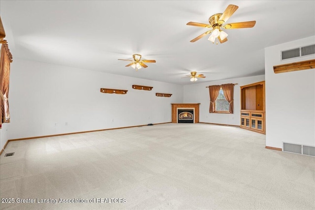 unfurnished living room featuring visible vents, a ceiling fan, baseboards, and carpet flooring