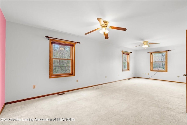 empty room featuring carpet flooring, baseboards, visible vents, and ceiling fan