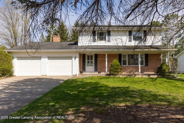 traditional-style house featuring a front yard, a chimney, brick siding, an attached garage, and driveway