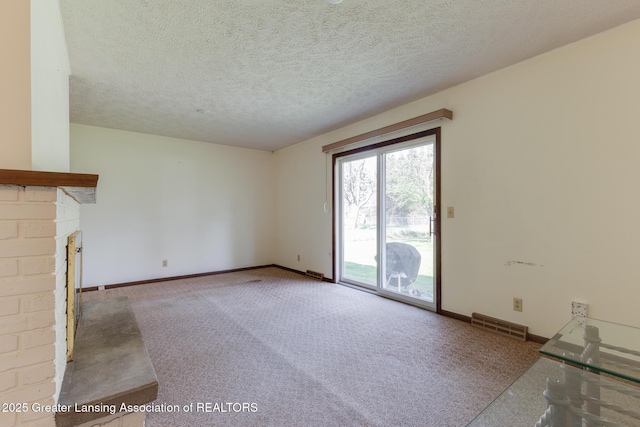 unfurnished living room featuring a brick fireplace, baseboards, visible vents, and carpet