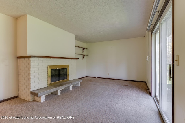 unfurnished living room featuring carpet floors, a textured ceiling, baseboards, and a brick fireplace