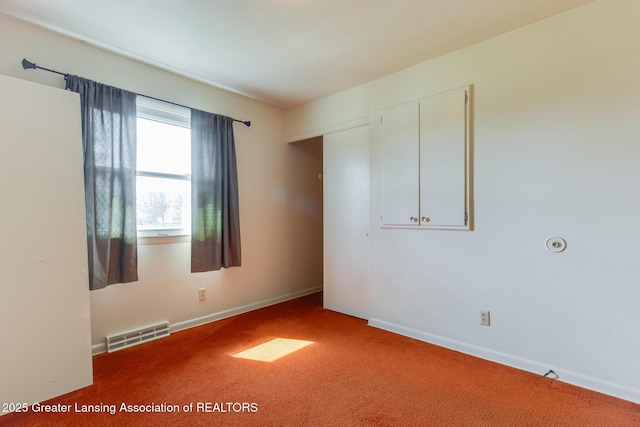 empty room with visible vents, carpet flooring, and baseboards
