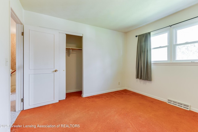 unfurnished bedroom featuring light colored carpet, baseboards, visible vents, and a closet