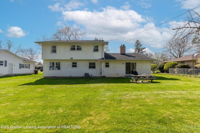 rear view of house featuring a lawn, central AC unit, fence, and a chimney