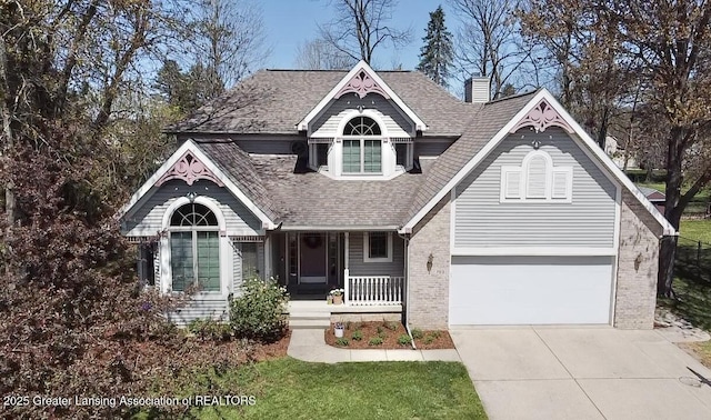 view of front of house with a shingled roof, brick siding, a porch, a chimney, and driveway