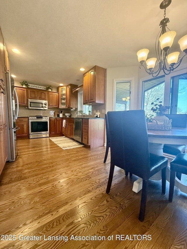 dining room with recessed lighting, wood finished floors, and a notable chandelier