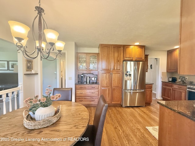 dining space featuring light wood-style floors and a notable chandelier