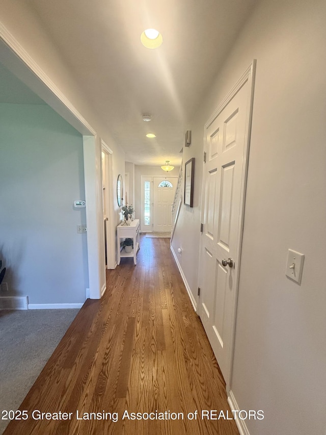 hallway with baseboards and wood finished floors