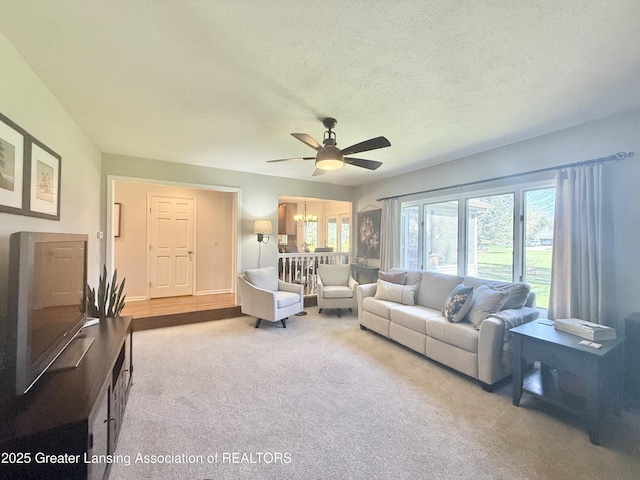 carpeted living room featuring a ceiling fan, a textured ceiling, and plenty of natural light