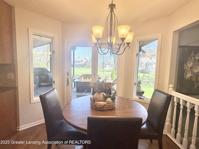 dining area with baseboards, a chandelier, and dark wood-style floors