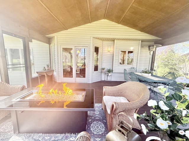 sunroom with outdoor dining area and a fire pit