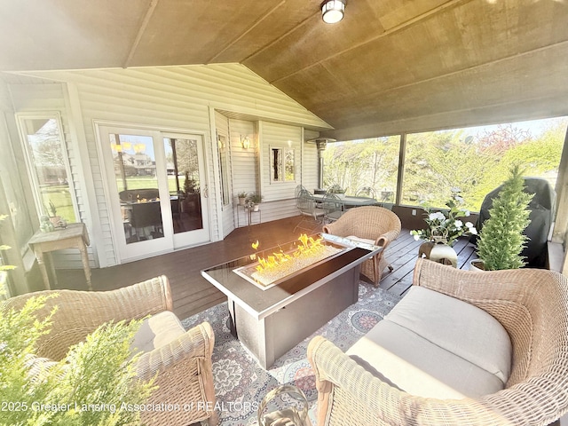 sunroom / solarium featuring an outdoor living space with a fire pit