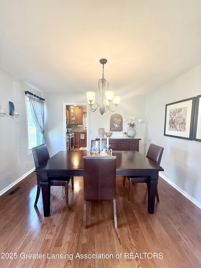 dining area with an inviting chandelier, baseboards, dark wood-style floors, and visible vents