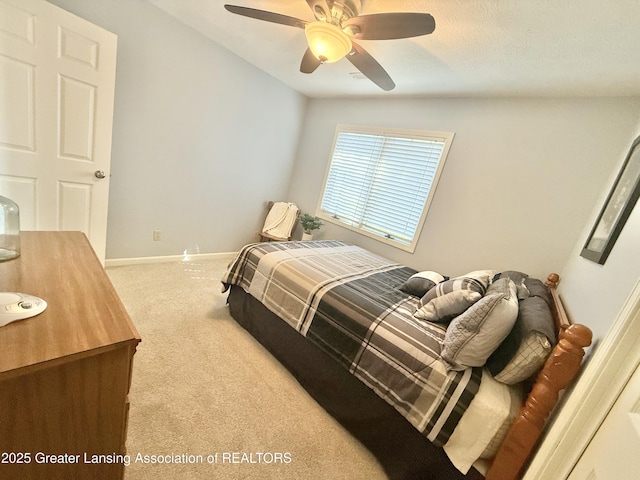 carpeted bedroom featuring baseboards and a ceiling fan