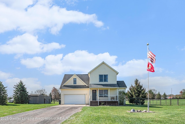 traditional-style house with a porch, aphalt driveway, fence, and a front lawn