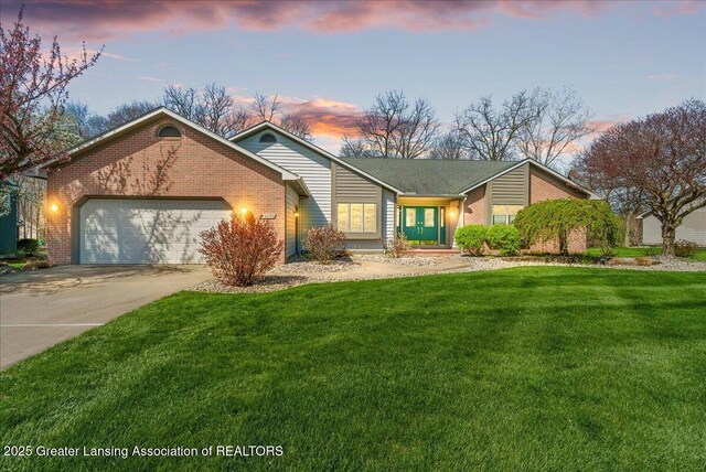 ranch-style home with brick siding, an attached garage, a front yard, and concrete driveway