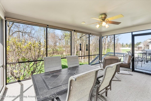 sunroom with outdoor dining area and ceiling fan