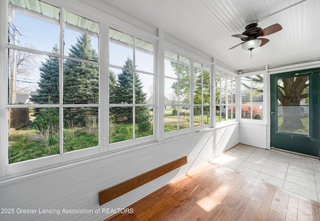 unfurnished sunroom with a ceiling fan