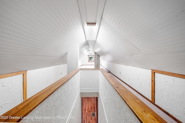 additional living space with wooden ceiling, a textured wall, and lofted ceiling