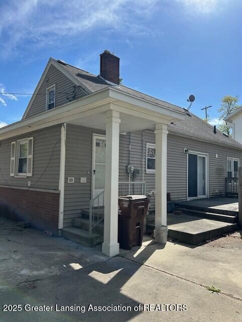 back of house featuring a chimney and a patio area