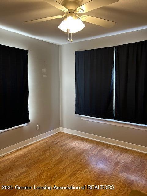 unfurnished room with light wood-type flooring and baseboards