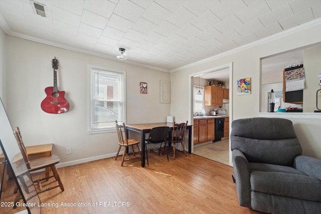 interior space with crown molding, baseboards, visible vents, and light wood-type flooring