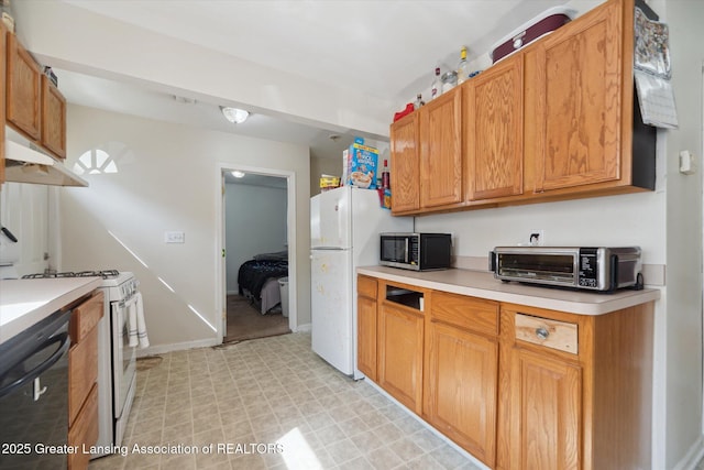 kitchen with light countertops, a toaster, under cabinet range hood, and white appliances