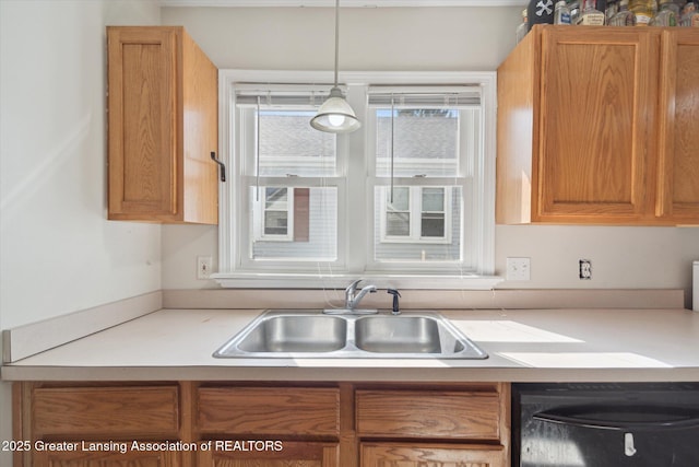 kitchen with a sink, dishwashing machine, decorative light fixtures, and light countertops