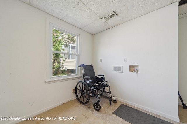 misc room with baseboards, visible vents, carpet floors, and a paneled ceiling