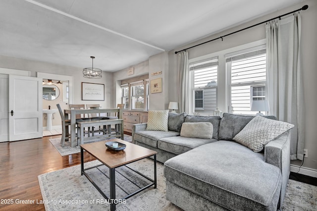 living area featuring wood finished floors and a chandelier
