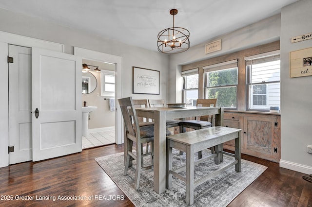 dining space with dark wood-style floors, a chandelier, and a wealth of natural light