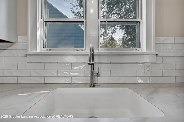 interior details with a sink and decorative backsplash